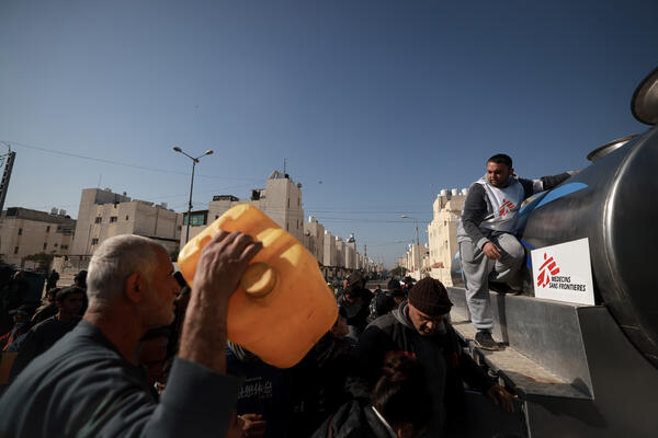 Youssef Al-Khishawi, an MSF water and sanitation agent, oversees a water distribution for displace