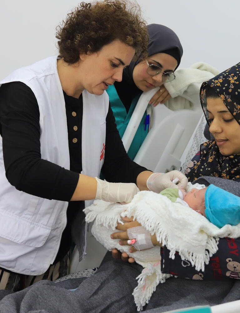 MSF medical staff discussing with patient and checking on newborn child in the Emirati hospital, Rafah, southern Gaza.